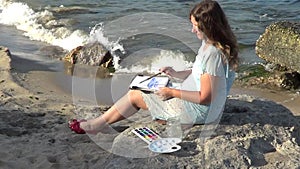 Woman painting sea on the beach