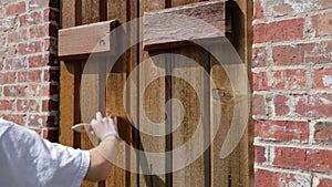 Woman painting shutters on house, slow motion