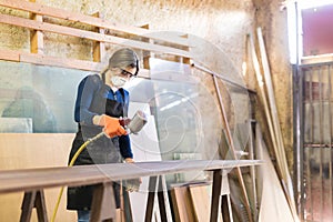 Woman painting table in a woodshop photo