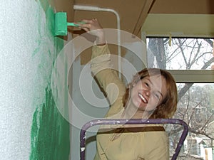 Woman painting a wall green