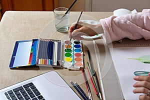 Woman painting with watercolors at home