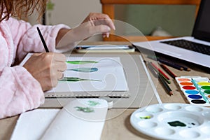 Woman painting with watercolors at home