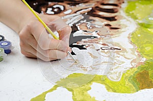 Woman paints on canvas. Woman`s hand holding a brush for drawing