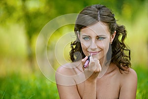 Woman paints her lips with lipstick