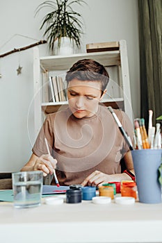 A woman paints with paints