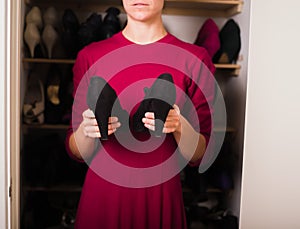 Woman with pair of shoes at home