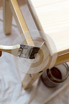 Woman Paiting Varnish onto a Wooden Stool