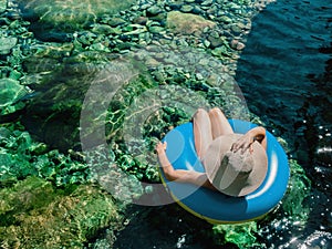 Woman with pamela on a float on a mountain river