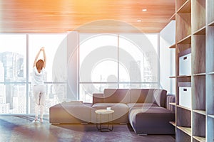 Woman in panoramic living room with bookcase