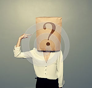 Woman with paper bag pointing at question