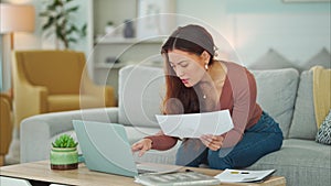 Woman, paper and laptop in living room on sofa working on project, assignment or task for college or business. Student