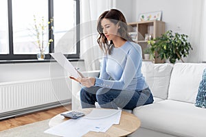 woman with papers and calculator at home