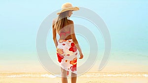 Woman in pareo and bikini at tropical beach