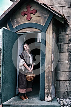 A woman parishioner at the door of an old Church in wild West America