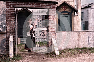 A woman parishioner at the wicket  of an ancient Church in the style of architecture of medieval Europe