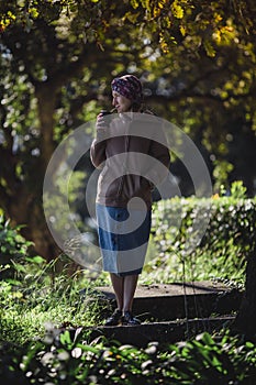 A woman in the park drinking yerba mate.