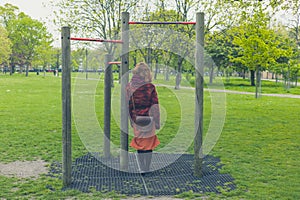 Woman in park by pull up bars
