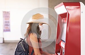 Woman passenger buying ticket with auromatic matchine at train station,Transport and insurance concept