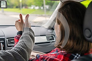 Woman passenger, man showing thumbs up traveling by car on the highway . Freedom  concept.