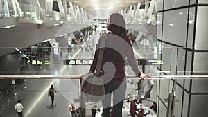 Woman passenger stand look at modern airport hall