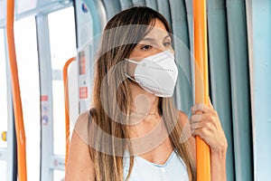 Woman passenger wearing medical hygiene protect mask. Standing inside subway train commuter in the city.