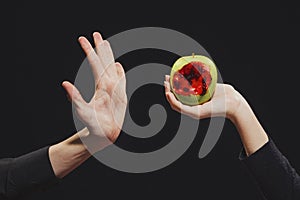 Woman passes a bitten blood apple into a man`s hand