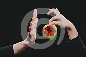 Woman passes a bitten blood apple into a man`s hand