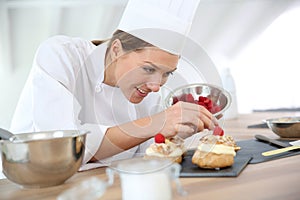 Woman pastry chef preparing desert photo