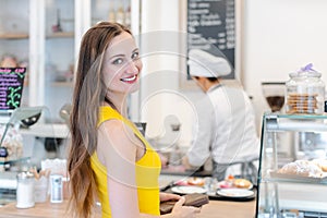 Woman in the pastry shop choosing sweet desserts