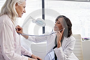 Woman Patient Having Medical Exam With Female Doctor In Office