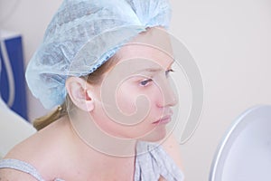 Woman patient in a hygienic hat expects the procedure in the doctor`s office. close-up. 4k