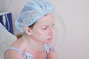 Woman patient in a hygienic hat expects the procedure in the doctor`s office. close-up. 4k