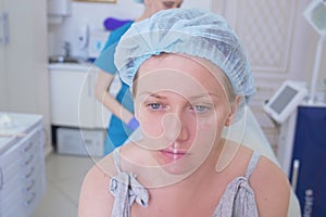 Woman patient in a hygienic hat expects the procedure in the doctor`s office. close-up. 4k