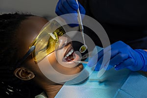 Woman patient in protective glasses visiting stomatology clinic for teeth clinic