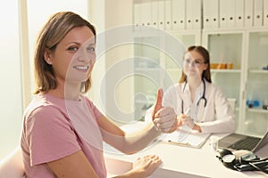 Woman patient showing thumb up at doctor appointment in clinic