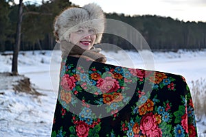 The woman in a pavlovo-posadsky scarf costs on the bank of the lake