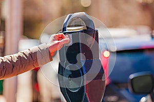 Woman pay on street parking meter pole with coin