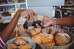 Woman paying bill through smartphone using nfc technology