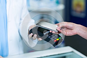 Woman paying bill through smartphone using NFC technology