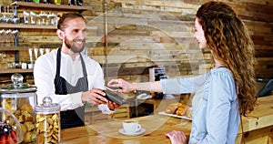 Woman paying bill through smartphone using NFC technology