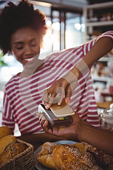 Woman paying bill through smartphone using nfc technology