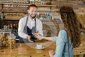 Woman paying bill through smartphone using NFC technology