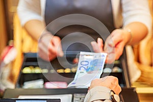 Woman is paying In cash with euro banknotes