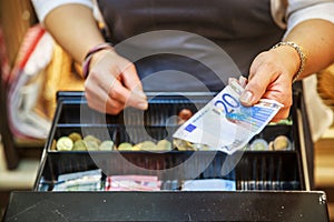 Woman is paying In cash with euro banknotes