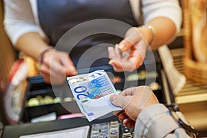 Woman is paying In cash with euro banknotes