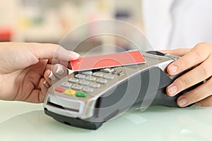 Woman paying with a contact less credit card in a shop