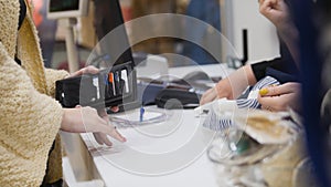 Woman paying by credit card in dress store - shopping concept