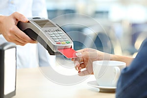 Woman paying with credit card reader in a bar