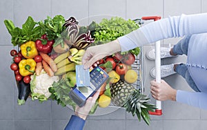 Woman paying for groceries using a credit card