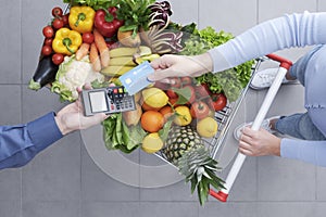 Woman paying for groceries using a credit card